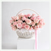 Coral Muse Vase with coral roses, peach gerbera, ranunculus and eucalyptus, styled as a modern clear cylinder vase on a light neutral studio background